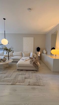 a living room filled with white furniture and lamps on top of it's walls