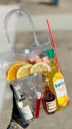 a person holding a bag full of drinks and condiments with orange slices in it