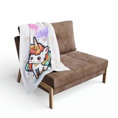 a couch with a blanket on it that has an image of a unicorn on it