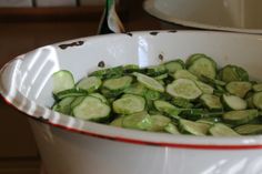 a white bowl filled with cucumbers on top of a table