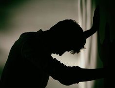 a man standing next to a curtain in the dark