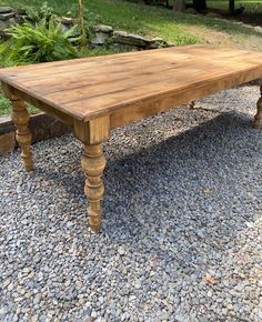 a wooden table sitting on top of gravel covered ground