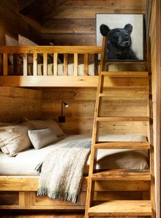 there is a bunk bed with a ladder to the bottom and a painting on the wall above it