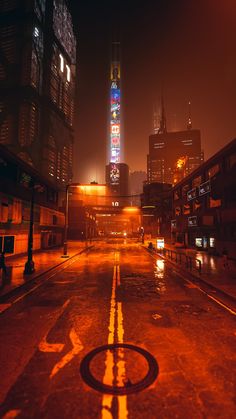 an empty city street at night with buildings in the background