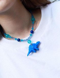 🦖 Dinosaur-Themed Statement Necklace - Unleash Your Inner Dino-Lover! These quirky dinosaur necklaces are the perfect choice for those who love bold, playful, and eco-friendly fashion. Each piece features an upcycled toy dinosaur, adding a touch of nostalgia and a unique, eye-catching charm. Ideal for anyone looking to stand out and make a statement, these necklaces bring a pop of color and personality to any outfit! ✨ Features: - Upcycled Toy Charm: Each necklace includes a toy dinosaur that's been given a second life, making it a sustainable and stylish choice. - Materials: Matte plastic beads for a soft, playful look, combined with glossy glass beads that add a hint of shine and contrast. - Stainless Steel Findings: Durable, tarnish-resistant hardware ensures your necklace stays lookin Dinosaur Necklace, Eco Friendly Fashion, Plastic Beads, Jurassic Park, Multiple Color, Second Life, Charm Necklaces, Charm Necklace, Pop Of Color