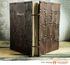 an open book with metal rivets on the front and back cover is sitting on a wooden table