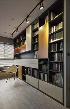 a room with many bookshelves and a chair in it's center area