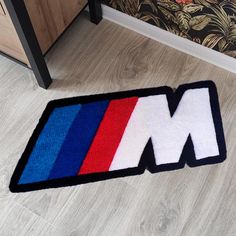 a door mat with the letter m in red, white, and blue on it