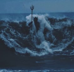 a person standing on top of a wave in the ocean with an oar sticking out of it