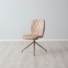 a beige chair sitting on top of a wooden table next to a white wall and floor