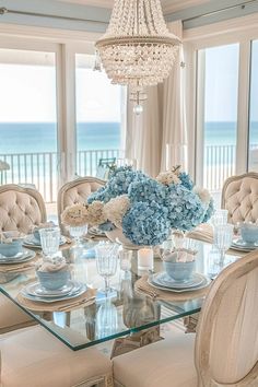 a dining room table with blue and white flowers on it's centerpieces