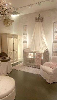 a baby's room with white furniture and chandelier