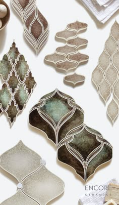 several decorative tiles are arranged on a white surface, including one with an egg in the middle