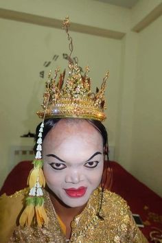 a woman wearing a gold crown with red lips