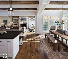 a large open concept living room with wood flooring and exposed beams in the ceiling