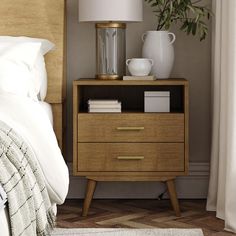 a nightstand with books and a vase on it