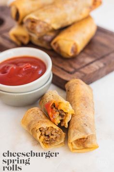 two burritos on a cutting board with dipping sauce