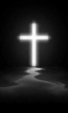 a white cross in the middle of a dark room