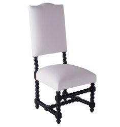 a white upholstered chair with black legs