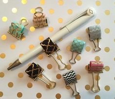 several different types of pens and magnets on a polka dot tablecloth with gold dots