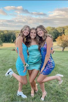 three girls in dresses posing for the camera