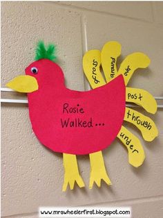 a red bird hanging on the side of a wall with words written on it's wings