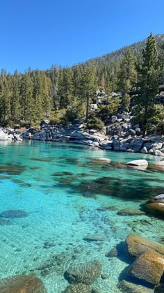 clear blue water surrounded by rocks and trees