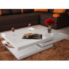 a white coffee table sitting on top of a carpeted floor next to a couch