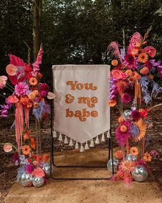 an orange and pink floral arrangement with a banner that says you & me bake