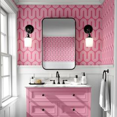 a bathroom with pink and white wallpaper on the walls, two sinks and a large mirror