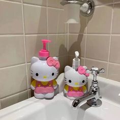 two hello kitty soap dispensers in a bathroom sink