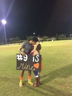 two people hugging each other while holding a sign