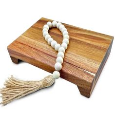 a wooden box with a white bead and tassel on the front, sitting next to it