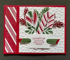 a close up of a greeting card with candy canes and ribbon on the front