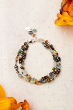 Infuse your wardrobe with the vibrant hues and endless possibilities of the Thrive Collection. This stunning piece boasts a colorful and versatile design that will elevate any outfit. Sterling Silver (lead and nickel free) Citrine, Iolite, Blue Apatite, Peridot, Labradorite, Garnet, Freshwater Pearl, Turquoise 7.5-8.5", adjustable with sterling silver lobster claw clasp We hand select our natural materials, thus there may be slight variations in color and/or size that will not detract from the o Floyd Va, Multistrand Bracelet, Silver Gold Earrings, Silver Gold Necklace, Multi Strand Bracelet, Pearl Design, Blue Apatite, Gold Collection, Designer Jewelry