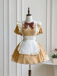 This price includes a dress and a brown bowknot.  Get ready to channel your inner maid with this stunning Khaki Lolita Fashion Apron Dress. Complete with a charming bowknot on the neckline, this dress is perfect for anyone looking to add a touch of elegance and whimsy to their wardrobe. Whether you're attending a tea party or simply want to showcase your love for Lolita fashion, this apron dress is sure to turn heads and make you feel like a true fashionista.   	 		 			Size 			S 			M 			L Yellow Maid Dress, Baking Outfit Cute, Cute Baking Outfit, Cute Doll Dress, Baking Outfit Aesthetic, Apron Reference, Bakery Outfit, Cute Maid Dress, Kawaii Apron