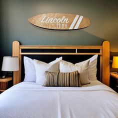 a bedroom with a surfboard on the wall above the bed and two nightstands