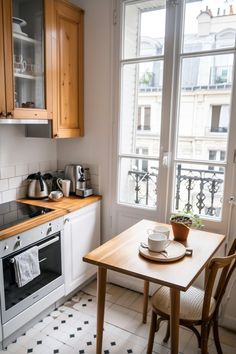 a small kitchen with an oven, sink and table in front of the stove top