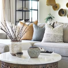 a living room filled with lots of furniture and pillows on top of a white table