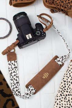 a camera and other accessories laid out on a white surface with leopard print fabric around it