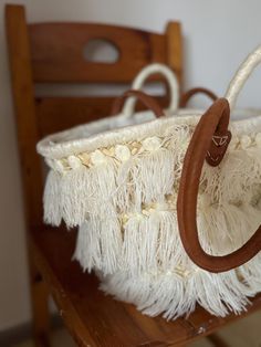 a white purse sitting on top of a wooden table next to a chair in a room