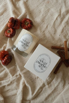 an open candle next to some cinnamon sticks and tomatoes on a white sheet with the label fresh figs