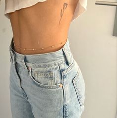 a woman's stomach with a small flower tattoo on her left side and the bottom part of her lower body