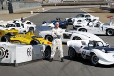 a man standing in front of some race cars