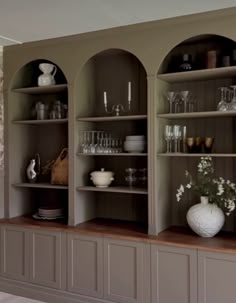 the shelves are filled with dishes and glasses