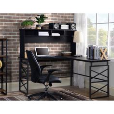 a computer desk with a laptop on top of it next to a book shelf and chair