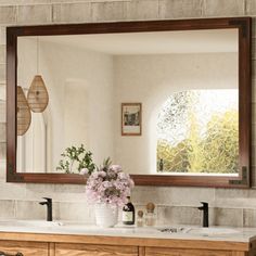 a bathroom with two sinks and a large mirror on the wall above it's counter