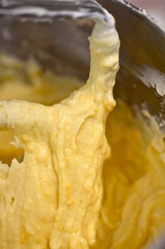 a metal mixing bowl filled with yellow batter