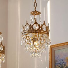 a chandelier hanging from the ceiling in a room with paintings on the wall