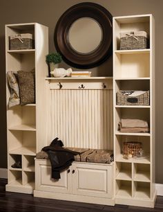 a white bookcase with an oval mirror above it